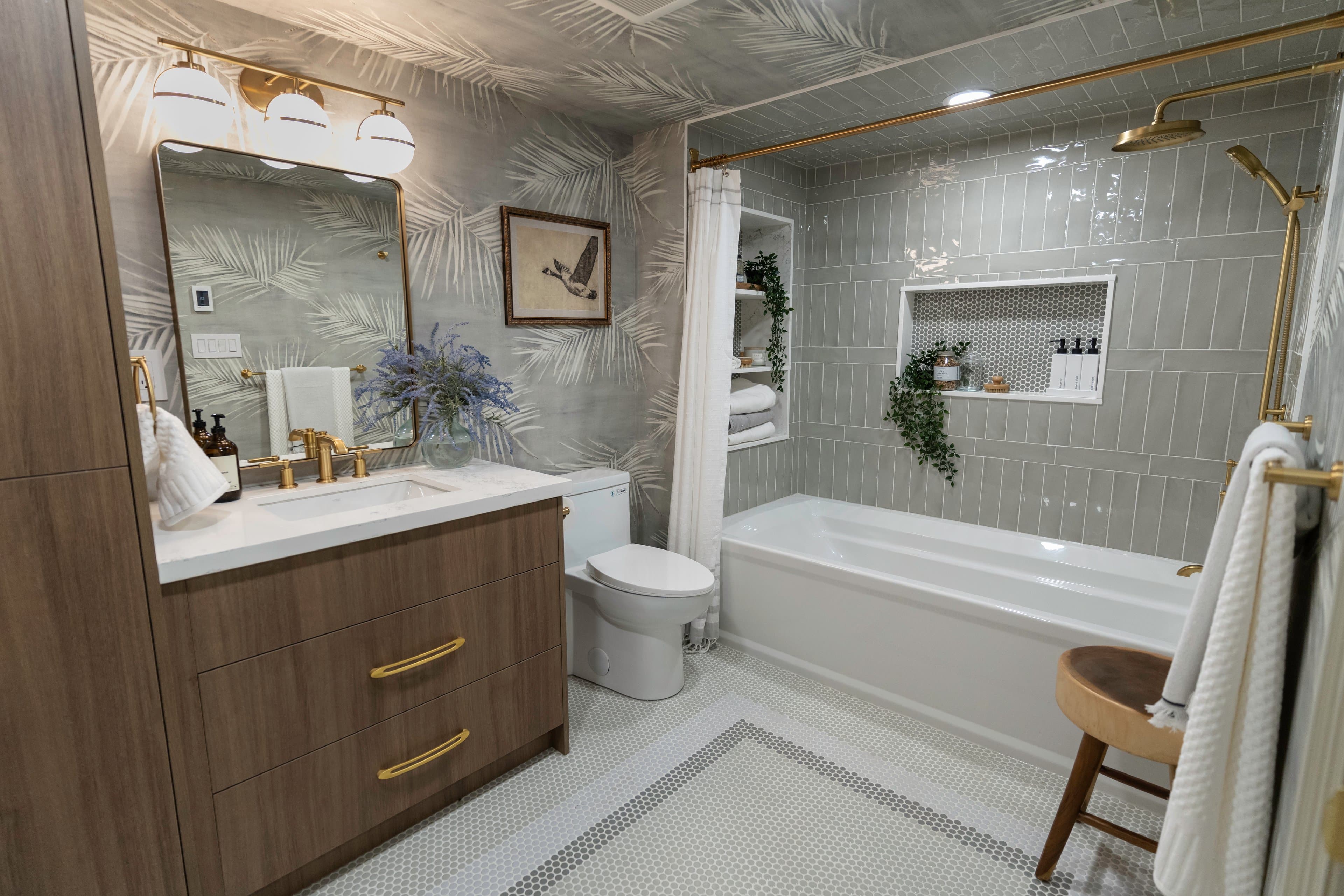 Modern bathroom with wood vanity, gold hardware, and mosaic tile floor