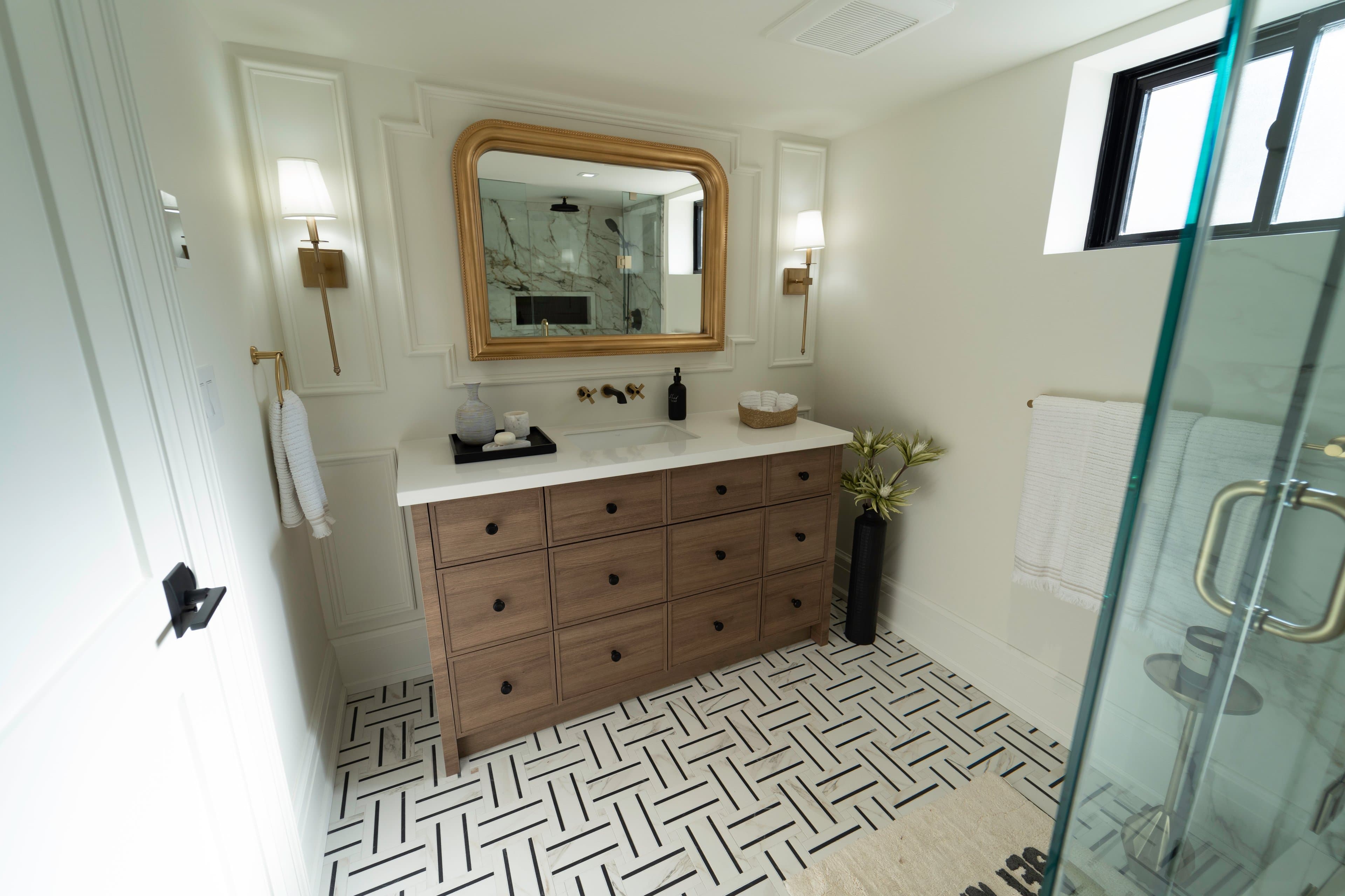 Modern bathroom with double vanity and gold-framed mirror