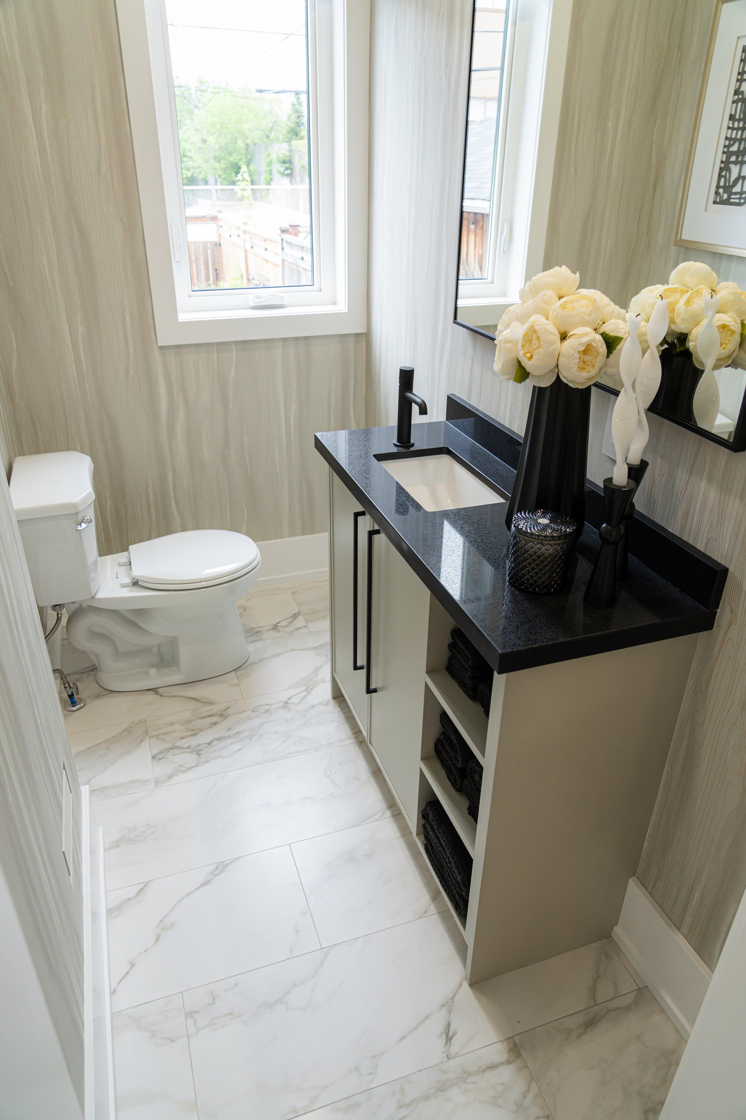 Modern bathroom with black granite countertop and marble flooring