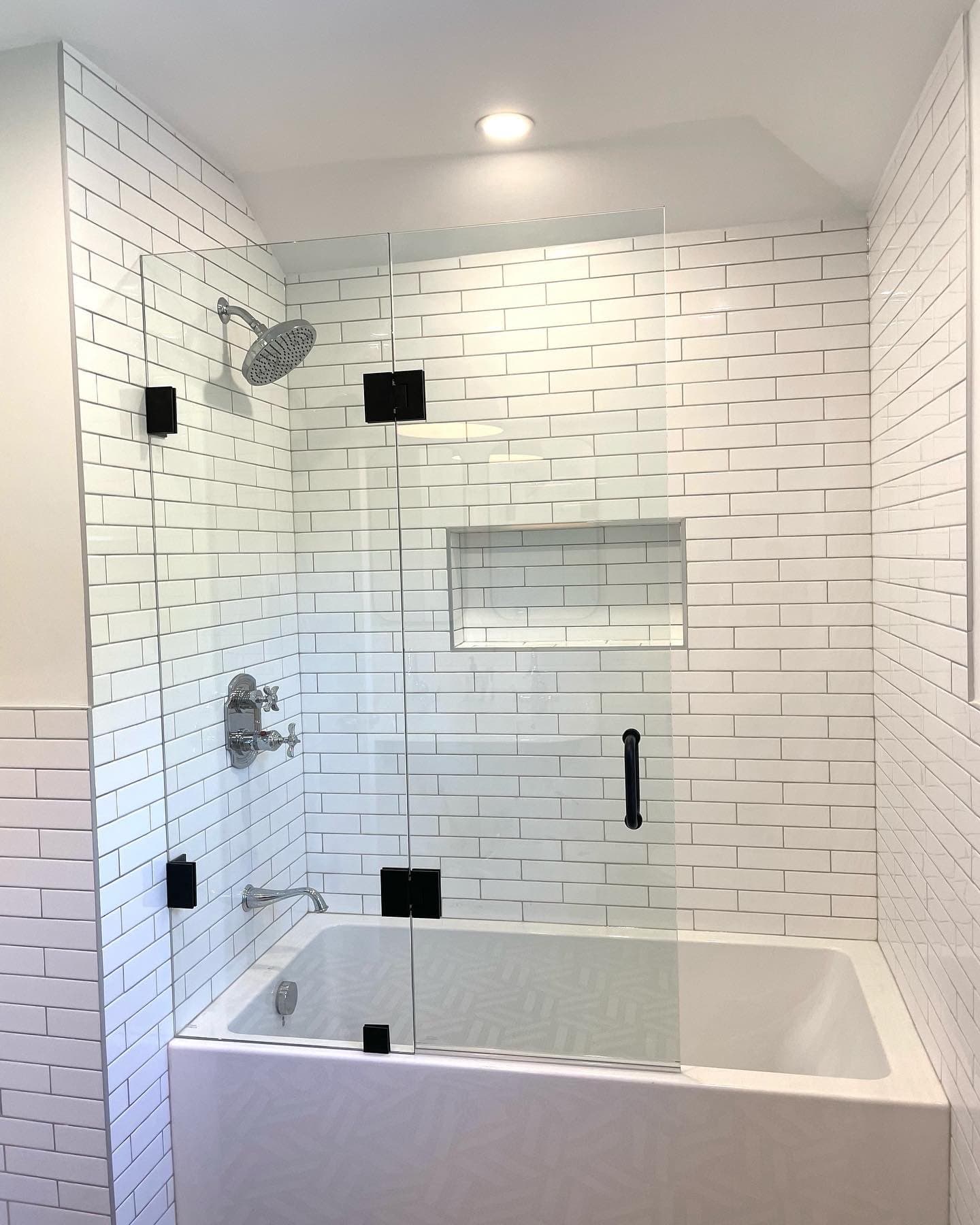 Modern bathroom with glass shower and subway tile design.